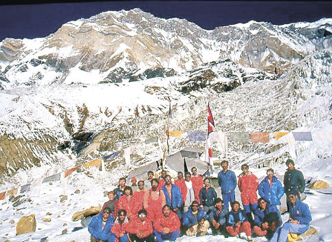 登山隊のメンバー。後方に見えるのは隊員が登頂を果たしたアンナプルナ1峰