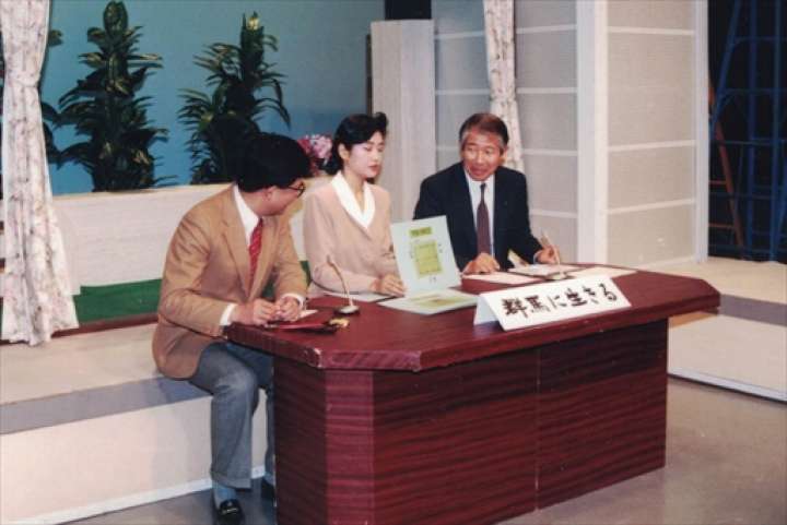 群馬テレビのスタジオで建造物の解説をする村田さん（右）
