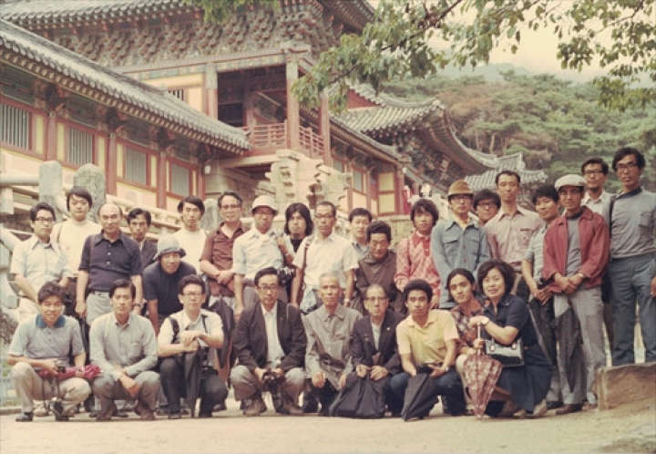 韓国古建築研修で仏国寺を訪れ、中腰で写真に納まる村田さん（後列左から5人目）