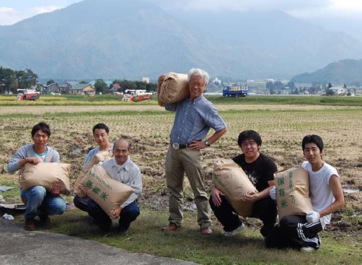 収穫されたばかりのコシヒカリを新潟県に毎年買いに行く（中央が黒澤さん）