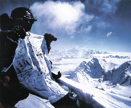 エベレスト山頂の八木原さん。手にしているＴシャツには映画関係者や登山スタッフの名前が書かれている