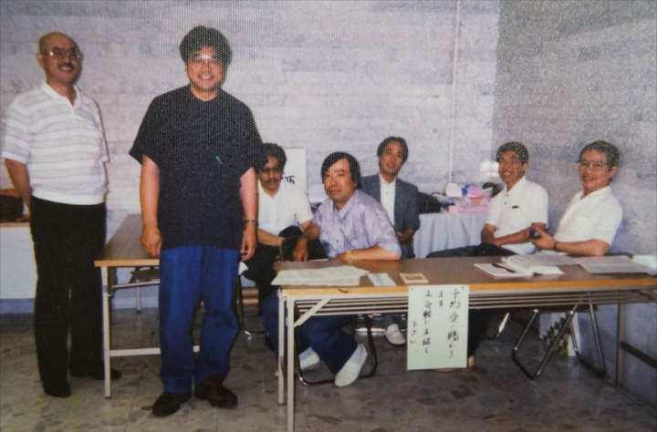 匠会の展示会場で、仲間と談笑する岡本さん（左から2人目）